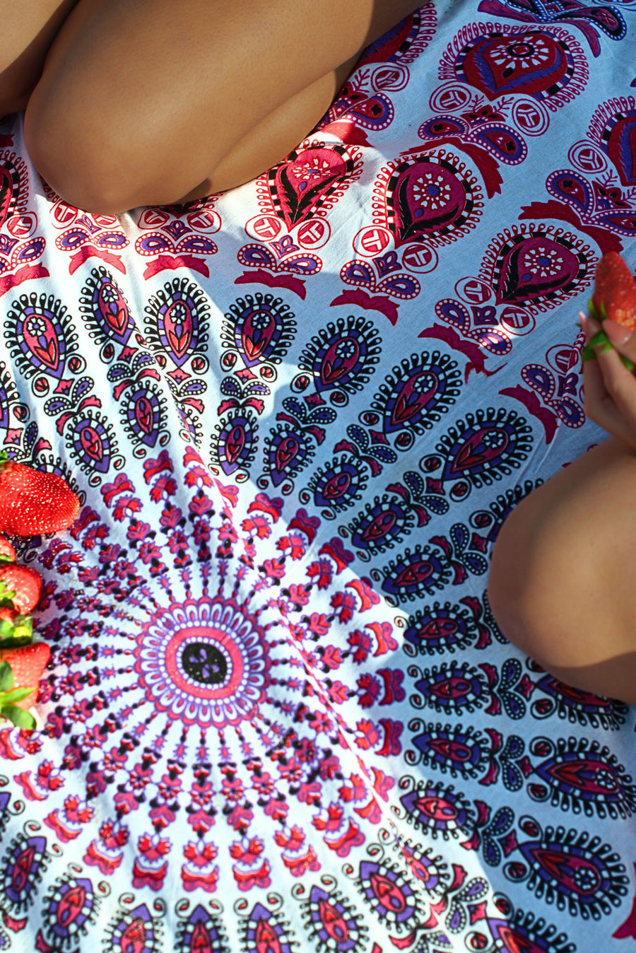 Detail van een mandala strandkleed in roze en paars