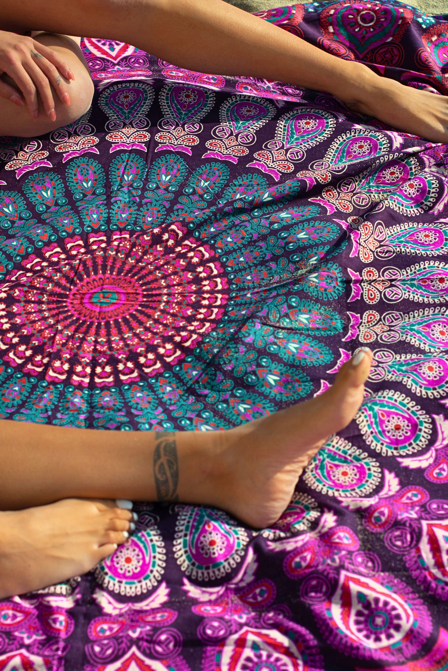 Mandala strandkleed in roze en paars op het strand