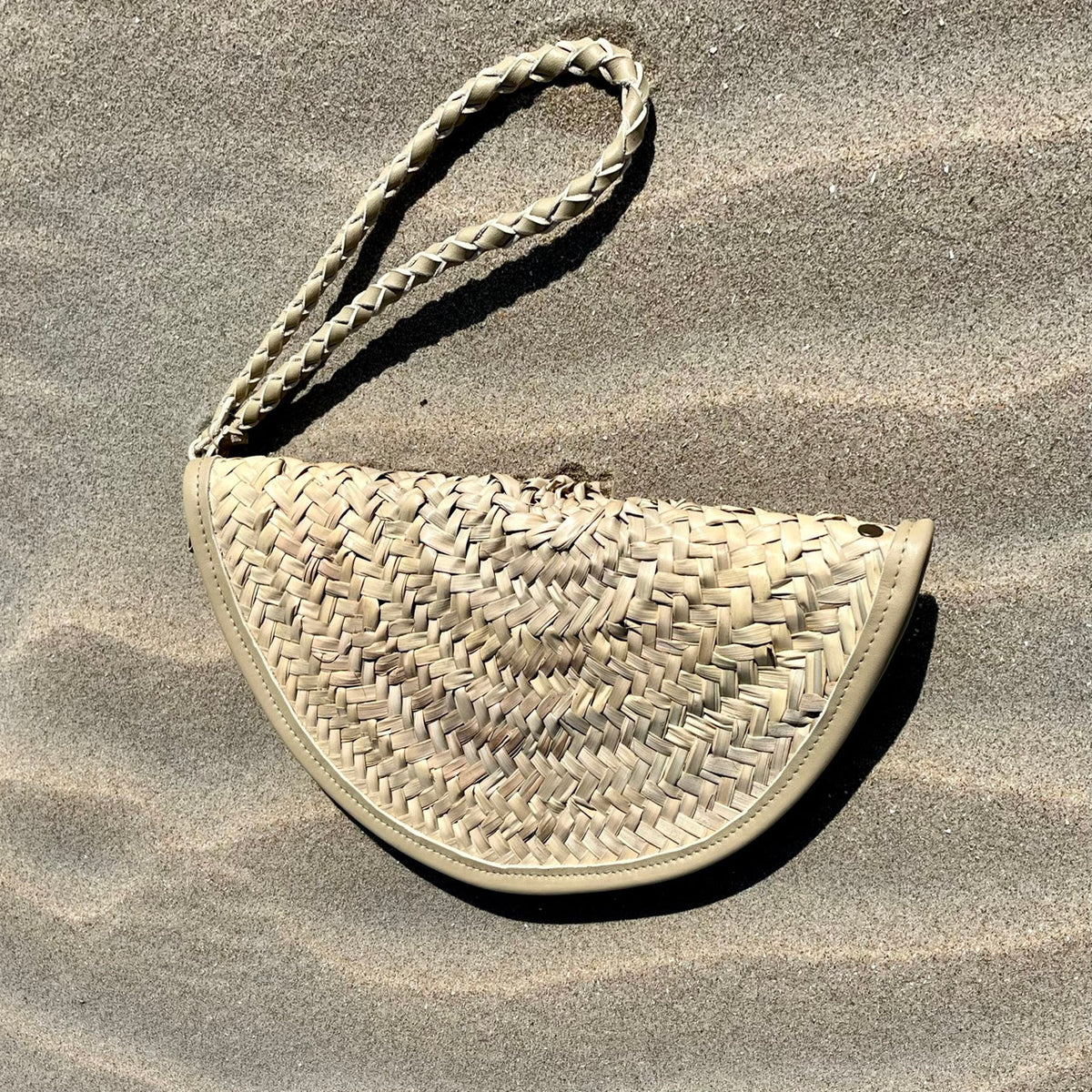 Basic rattan clutch, with wrist strap on the sand