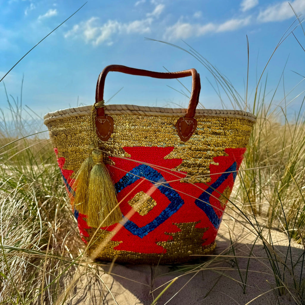 Boho rieten strandtas Aztec goud multi, in de duinen onder een blauwe lucht