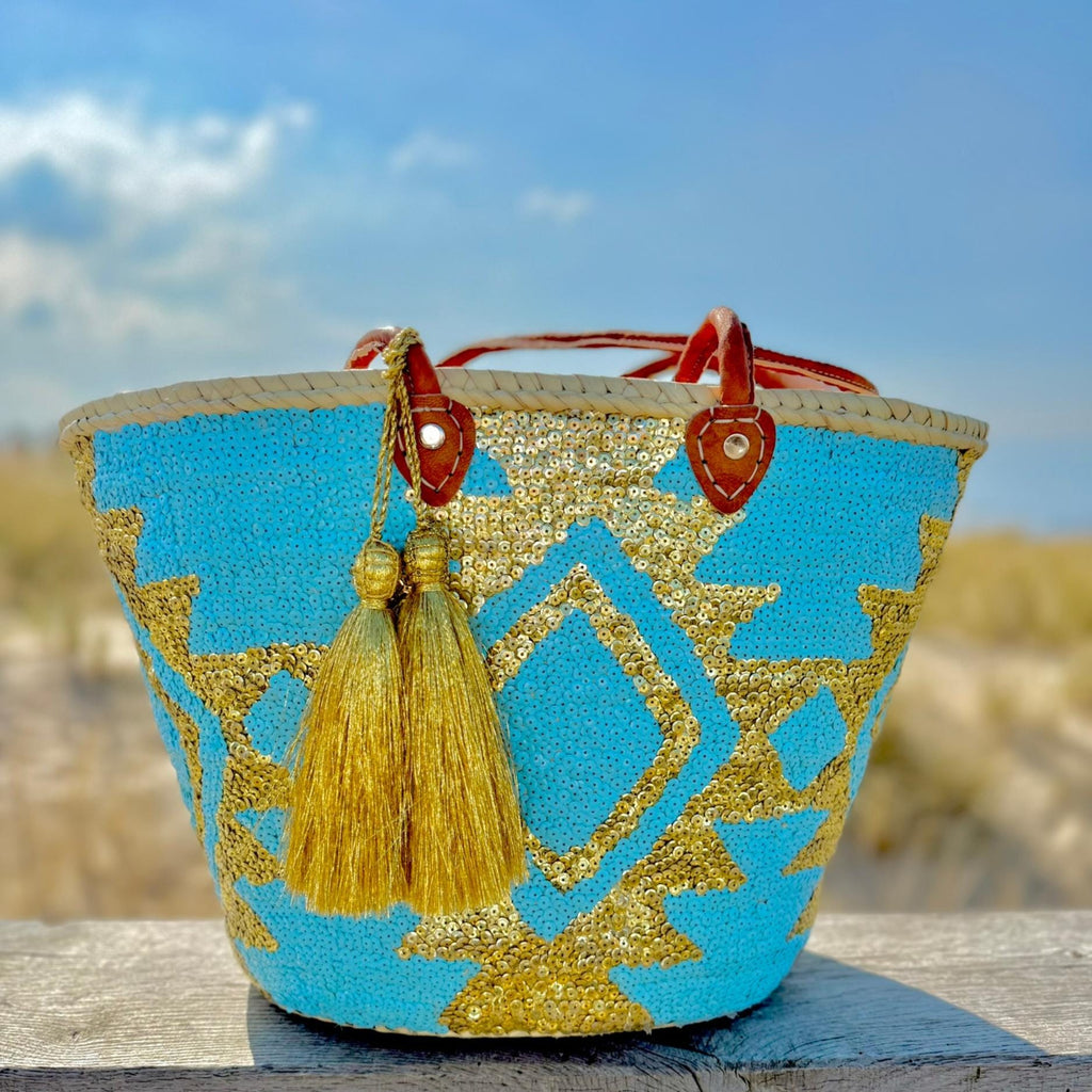 Boho rieten strandtas Aztec goud en turquoise, met gouden tassel in de duinen