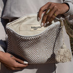Striped toiletry bag beige, on the lap with the travel bag