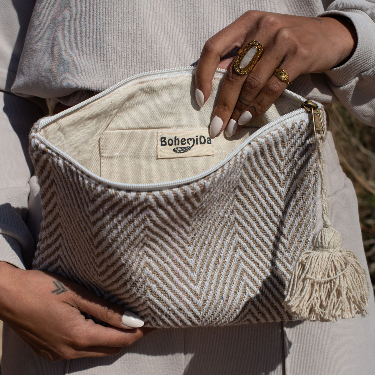 Striped toiletry bag beige, on the lap with the travel bag