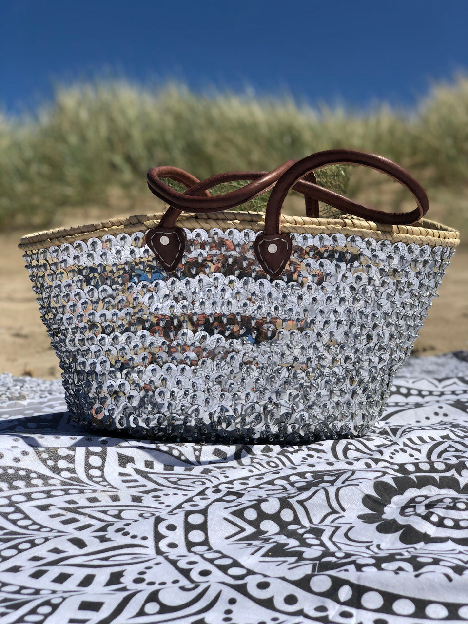 Large straw beach bag with sequins silver, on a beach blanket