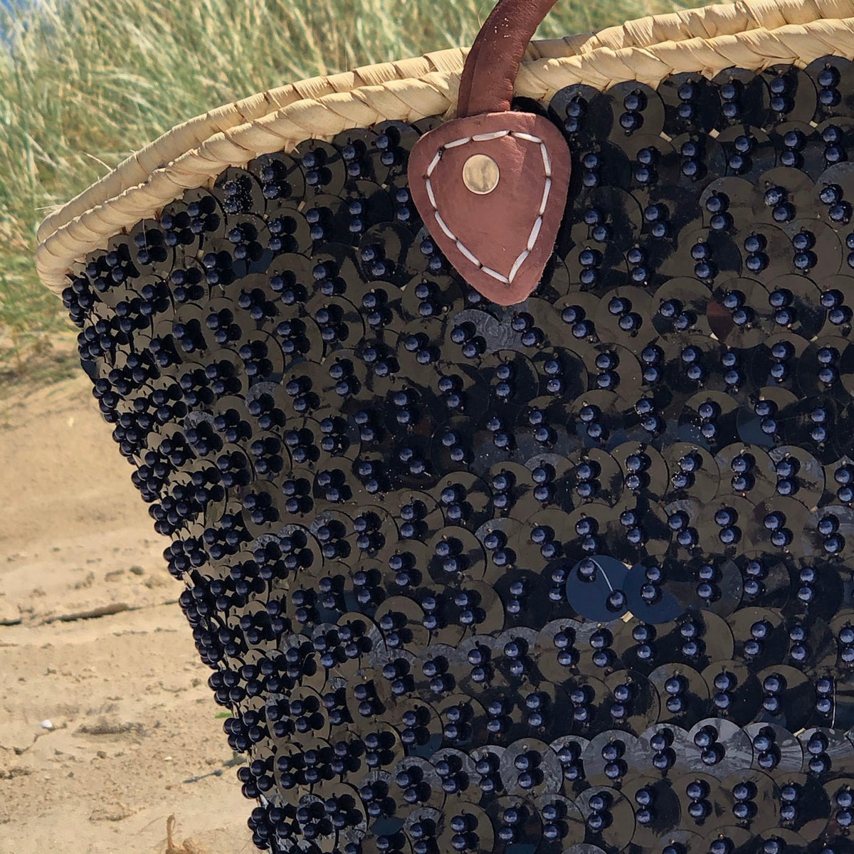 Grote rieten strandtas met pailletten zwart, close-up van de voorkant