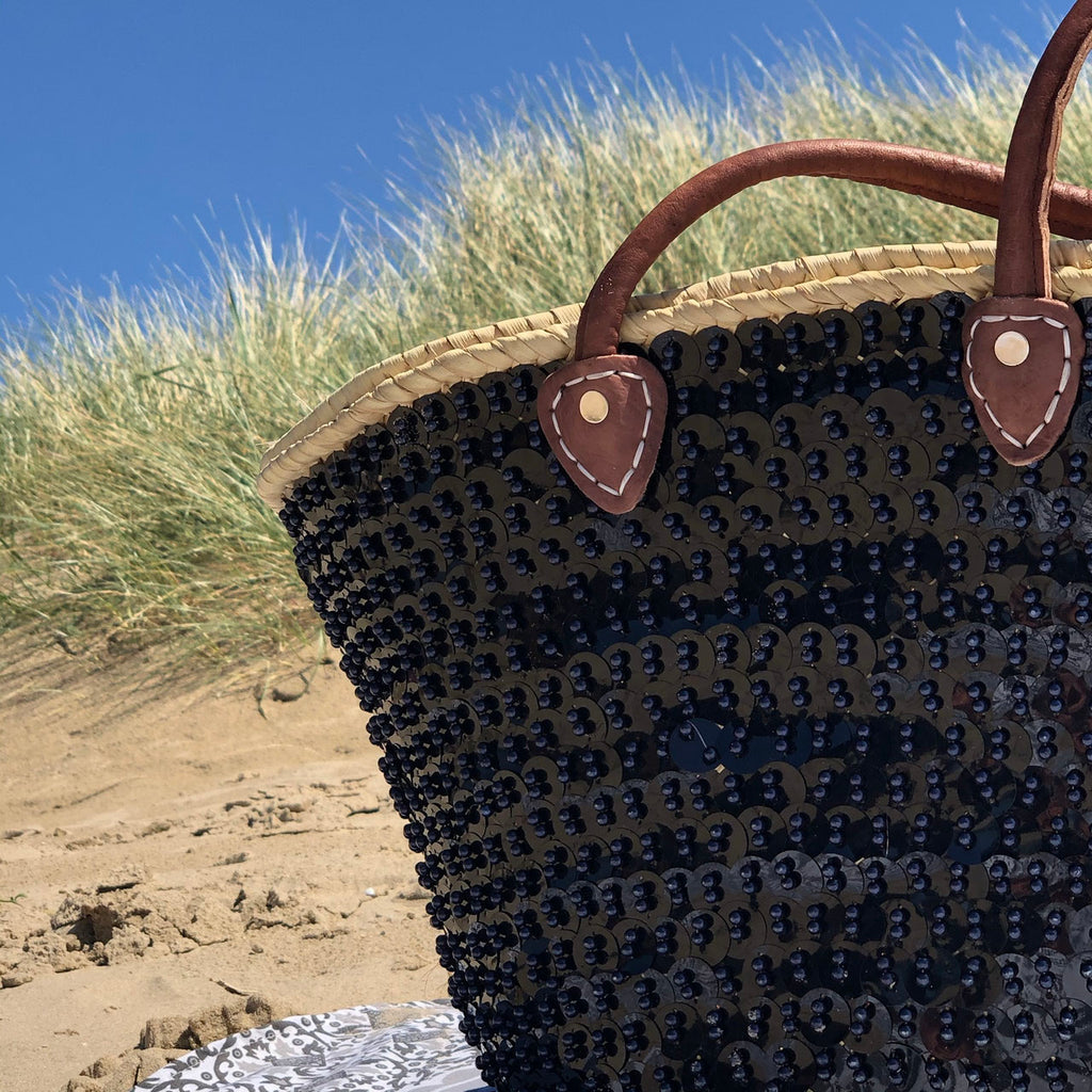Grote rieten strandtas met pailletten zwart, close-up van de zwarte pailletten