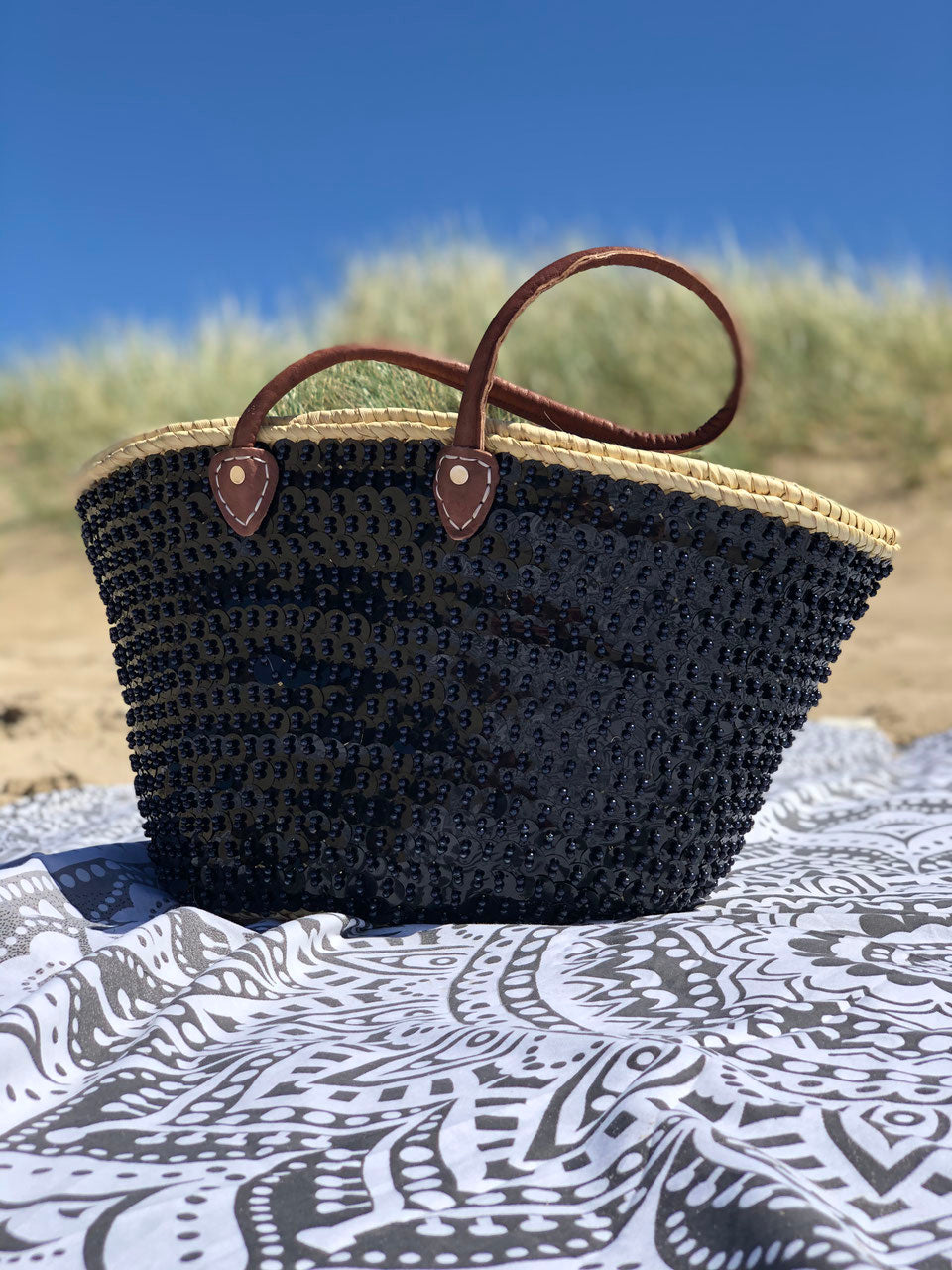 Grote rieten strandtas met pailletten zwart, vooraanzicht in de duinen