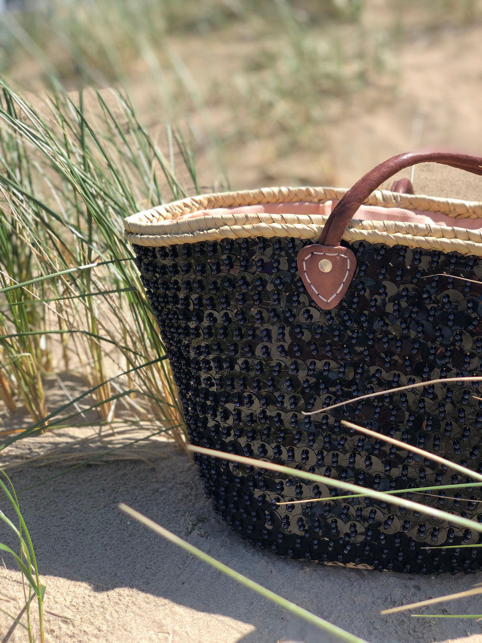 Grote rieten strandtas met pailletten zwart, zijaanzicht in de duinen