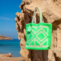 Ibiza strandtas Adventure groen, hangend aan een rots bij zee