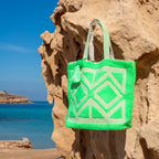 Ibiza strandtas Adventure groen, hangend aan een rots bij zee