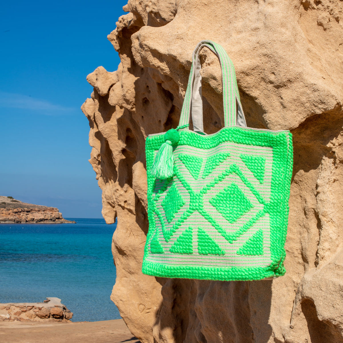 Ibiza strandtas Adventure groen, hangend aan een rots bij zee