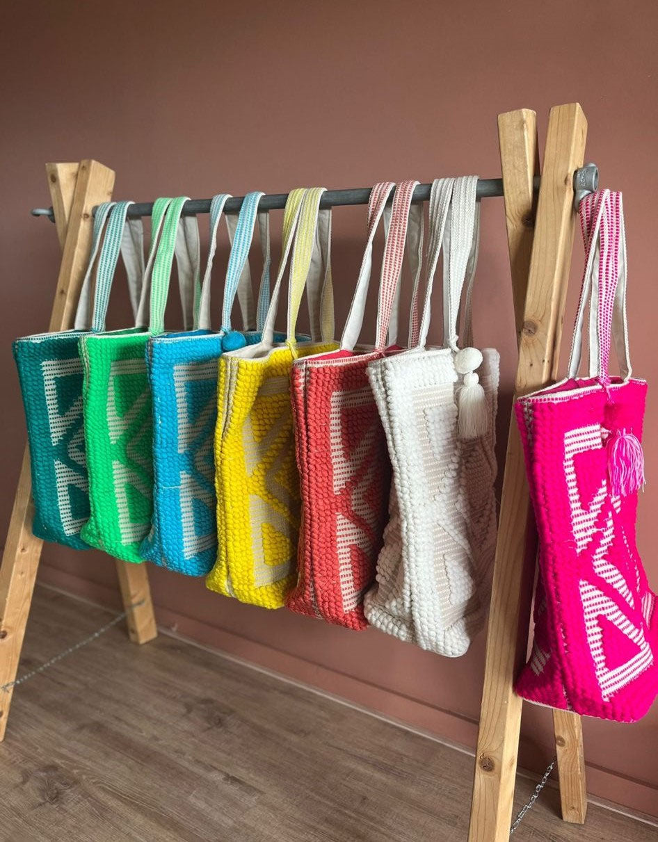 Ibiza strandtas Adventure groen, samen met alle kleuren aan een houten rek