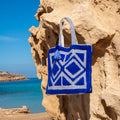 Ibiza strandtas blauw, hangend aan een rots bij zee