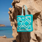 Ibiza beach bag Laguna blue, hanging on a rock by the sea