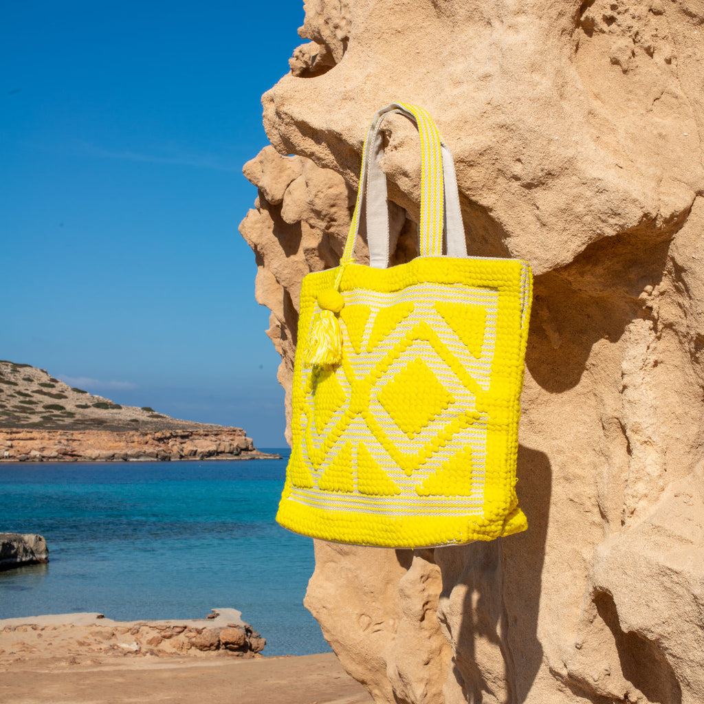 Ibiza strandtas Sunny geel, hangend aan een rots bij zee