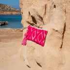 Ibiza toilettas en clutch fuchsia, op een rots in de zon