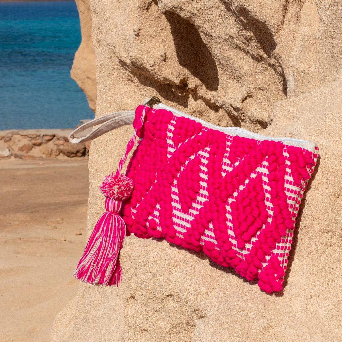 Ibiza toiletry bag and clutch fuchsia, on a sunny rock