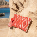 Ibiza toilettas en clutch koraal, op een zonnige rots