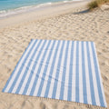 Luxe XXL hamamdoek lichtblauw gestreept 240x210 cm, uitgespreid op het zand