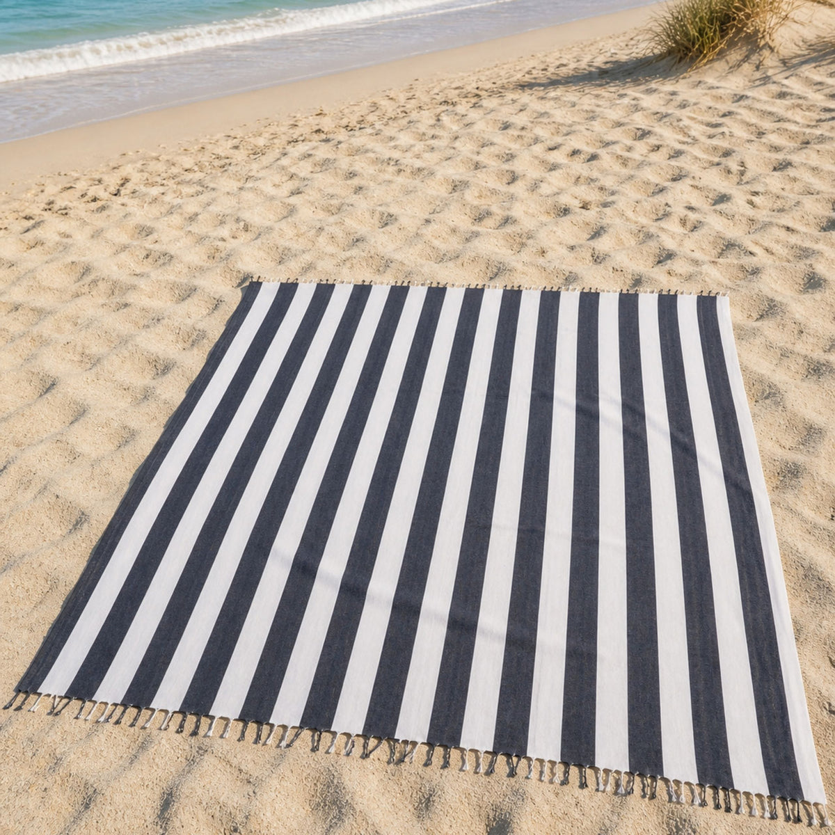 Luxe XXL hamamdoek zwart gestreept 240x210 cm, uitgespreid op het zand