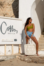 Ibiza strandtas Beige chic gedragen bij witte muur op Ibiza