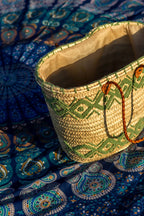 Rattan shopper with colourful embroidery light green on a blue mandala beach blanket