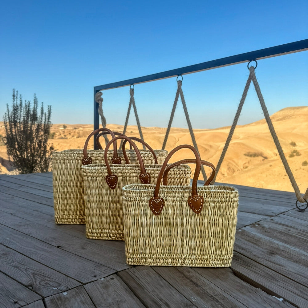 Rieten shopper Faria in drie maten op een houten schommel in de zon