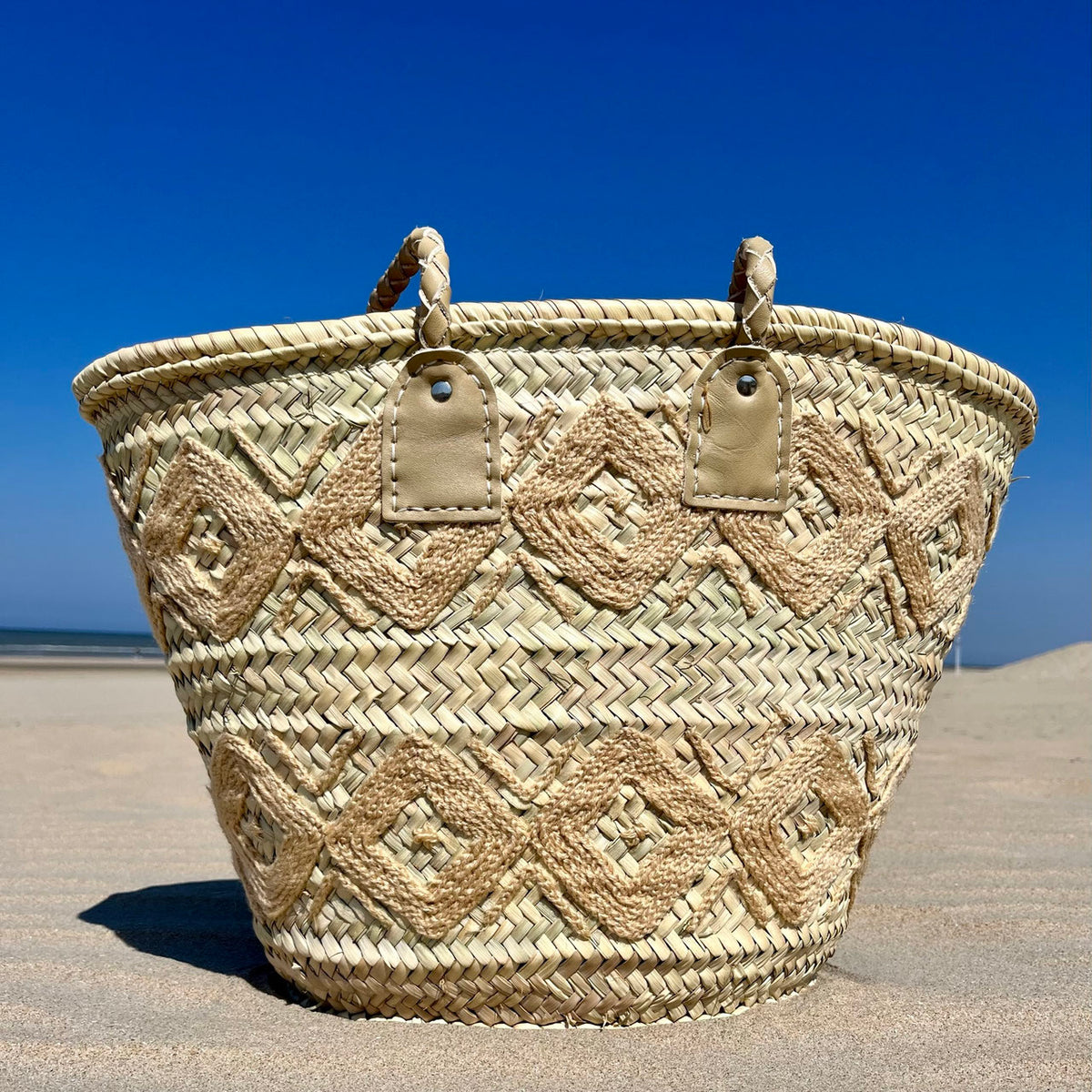 Rieten shopper met kleurrijk borduurwerk beige, op het strand