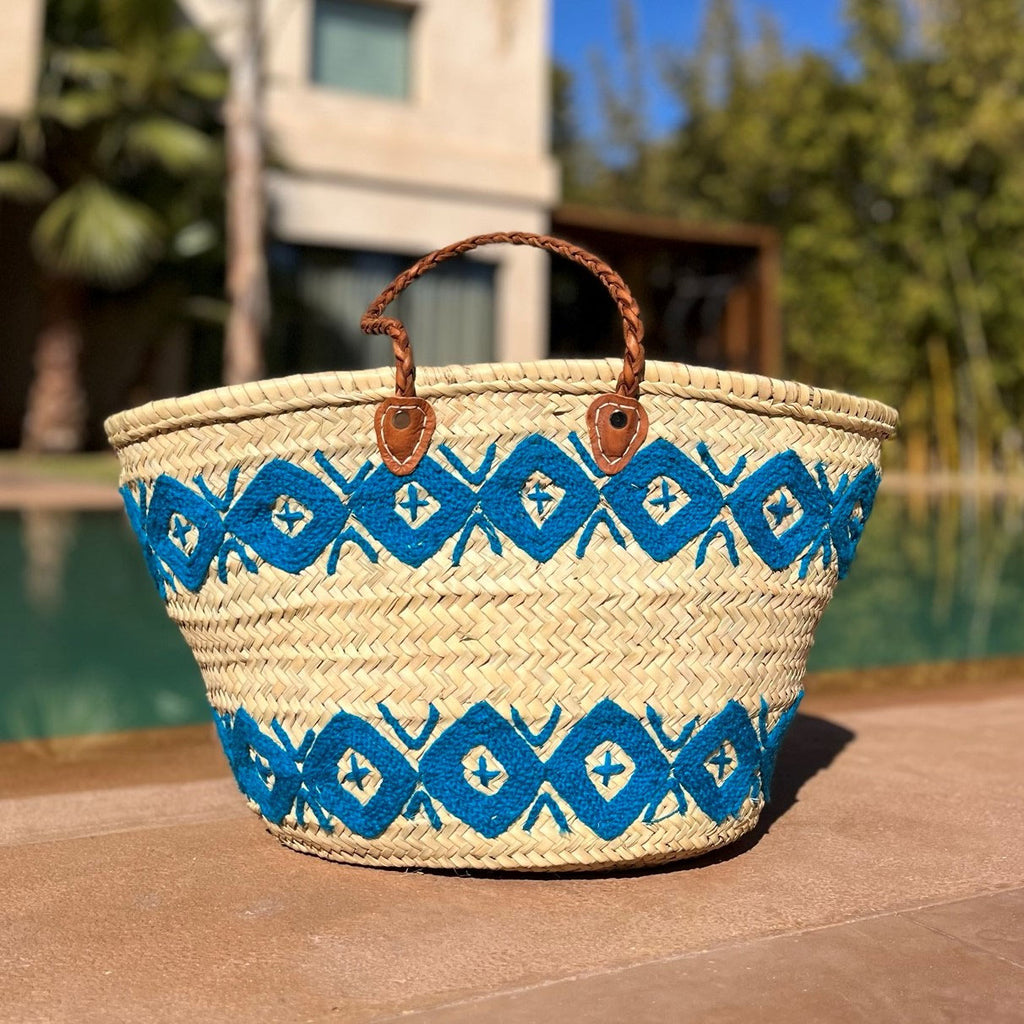 Rieten shopper met kleurrijk borduurwerk blauw, bij het zwembad