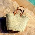 Rieten shopper met lange leren hengsels, buiten in de zon