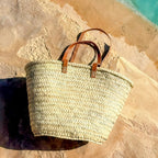 Rieten shopper met lange leren hengsels, buiten in de zon