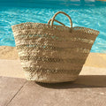 Straw beach bag Aisha, at the edge of the pool