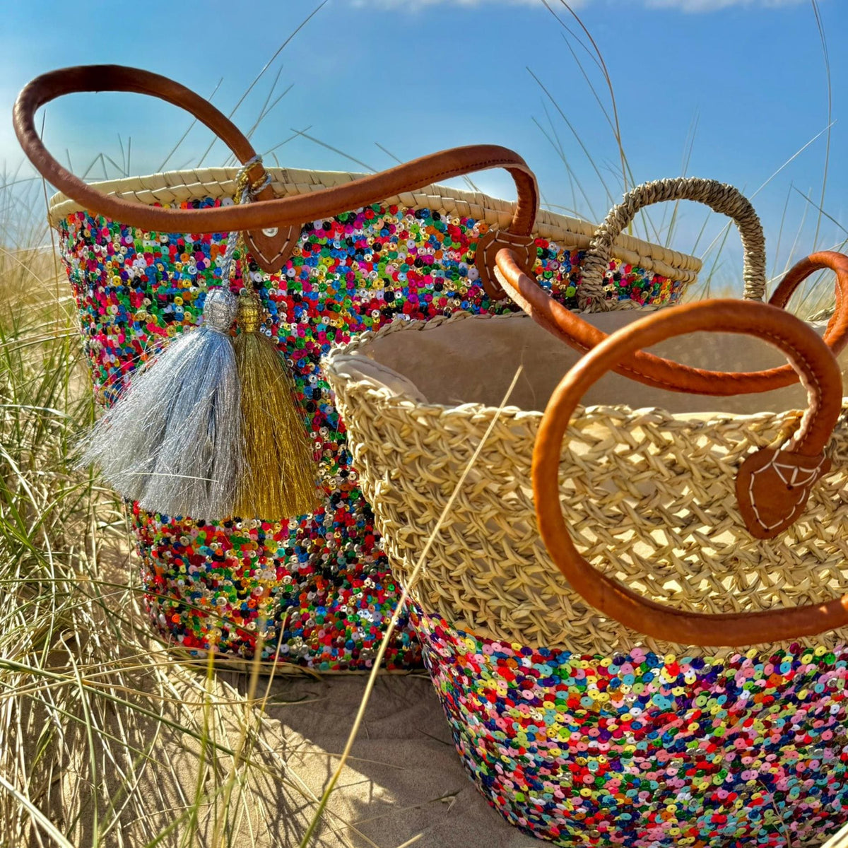 Rieten strandtas Dounia Multi met pailletten, met tassels in de duinen