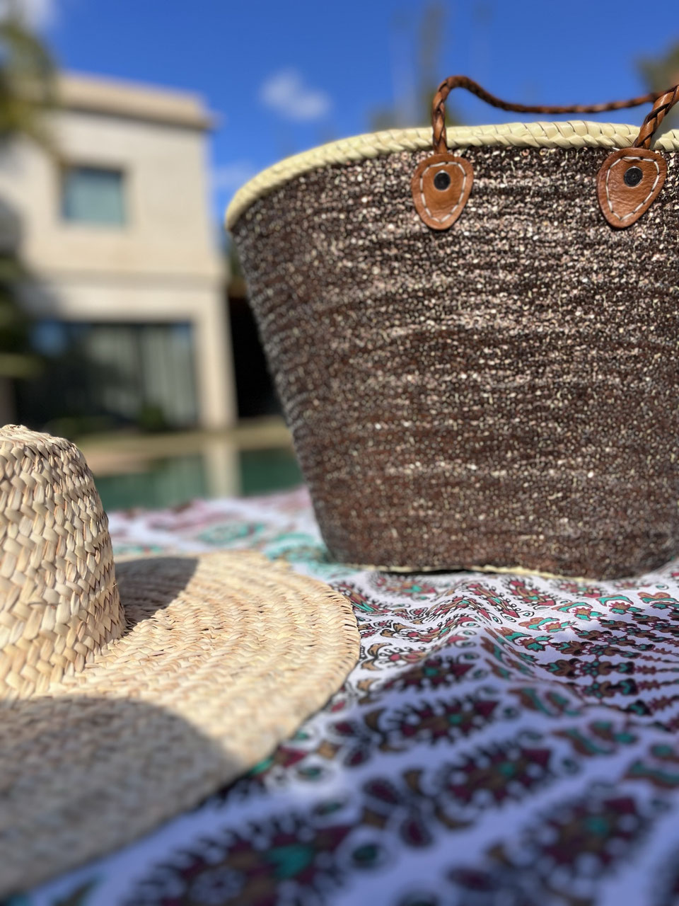 Straw beach bag with sequins brown, on a beach blanket