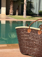 Straw beach bag with sequins brown, side view by the pool