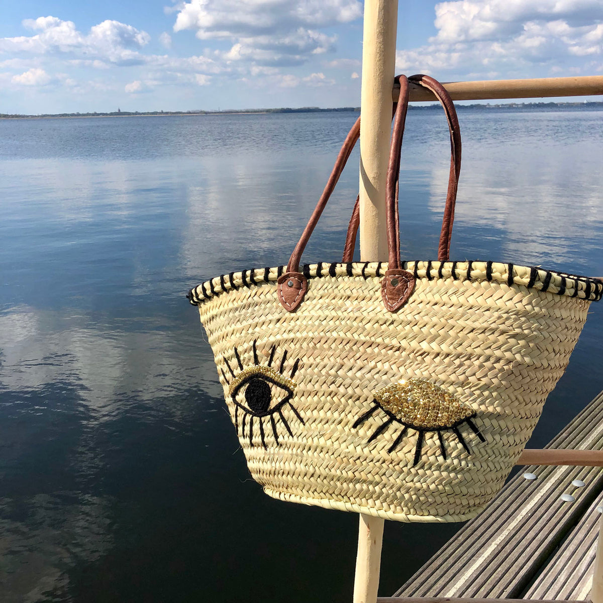Rieten strandtas met pailletten Eyes, aan het water