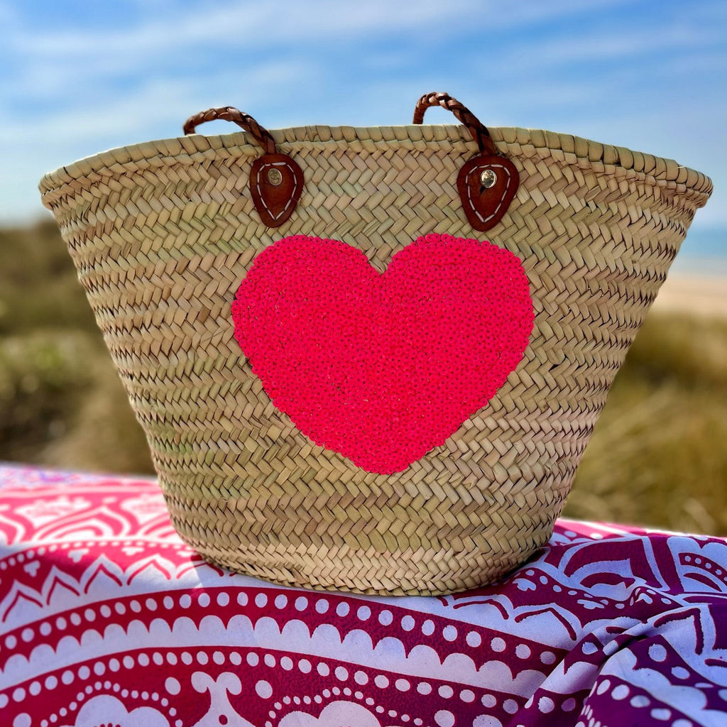 Rieten strandtas met pailletten Hart roze, op een strandlaken