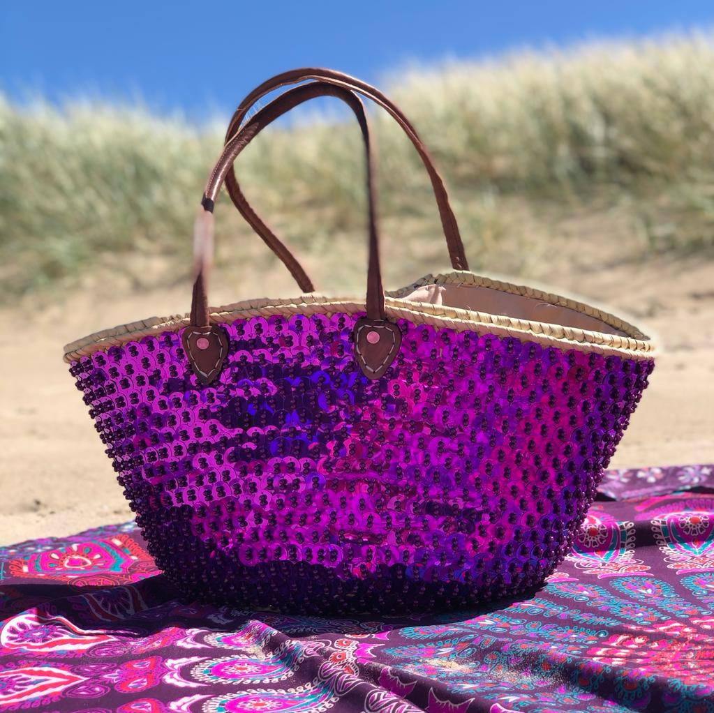 Straw beach bag with sequins purple, on a pink beach blanket