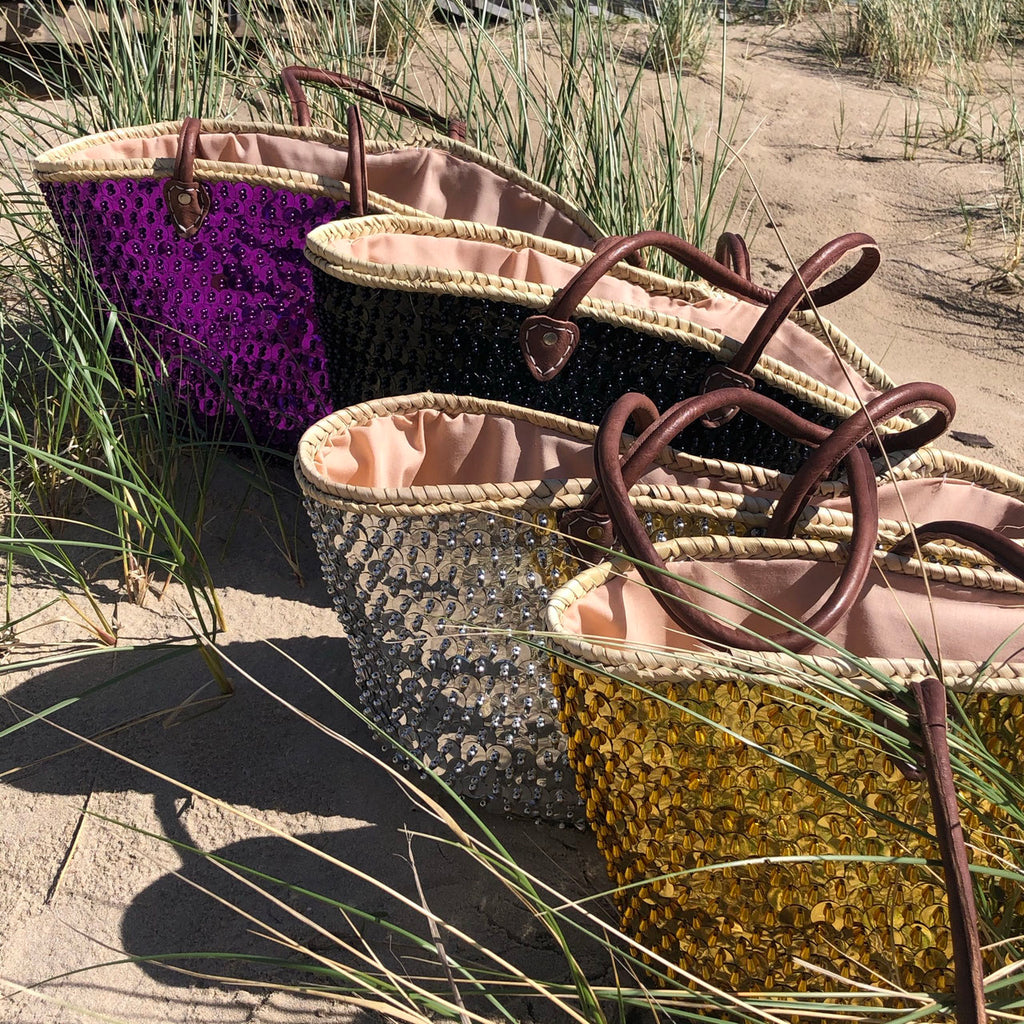 Straw beach bag with sequins purple, together with other sequin bags in the dunes