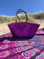 Straw beach bag with sequins purple, on a beach blanket