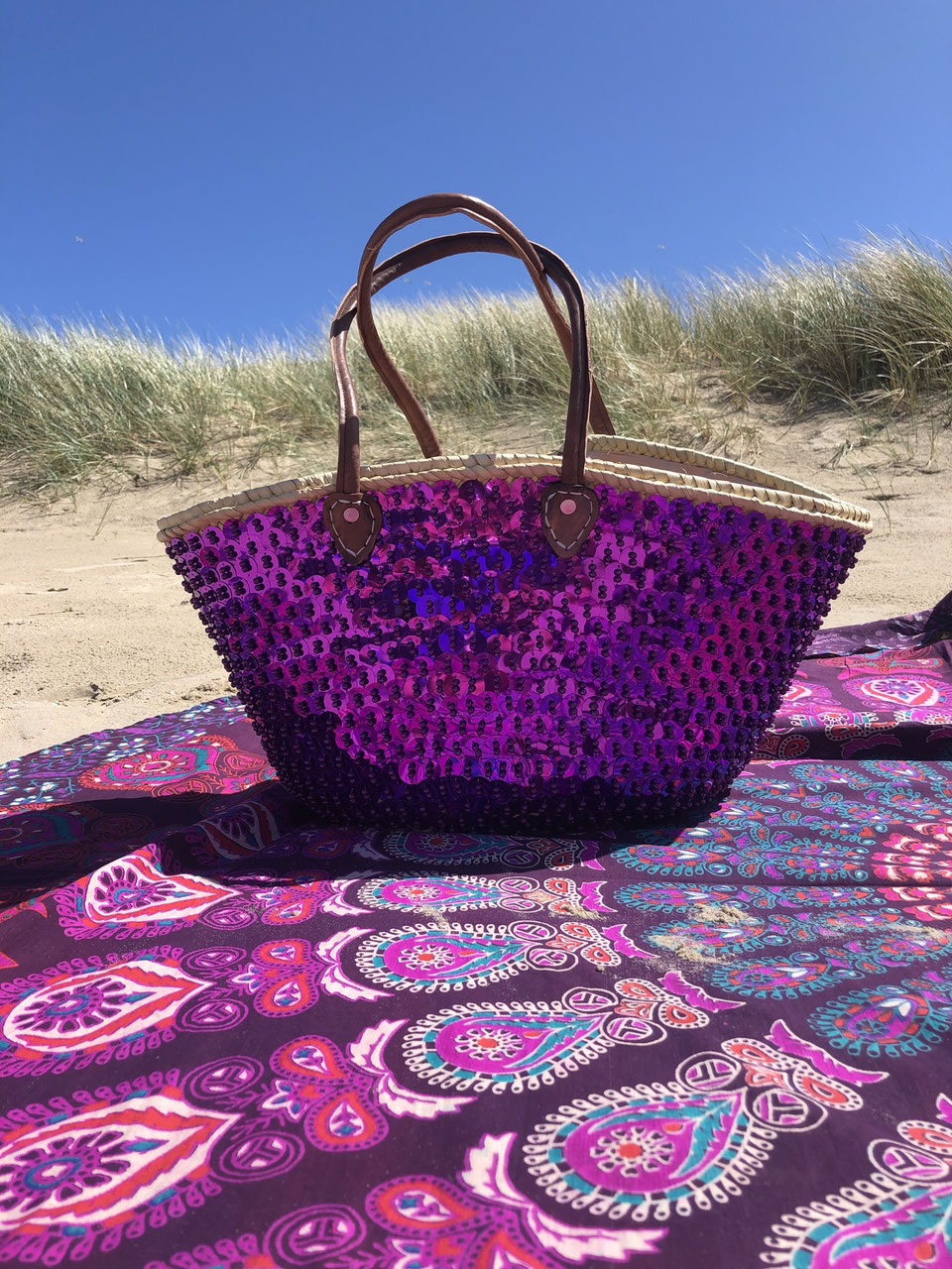 Straw beach bag with sequins purple, on a beach blanket