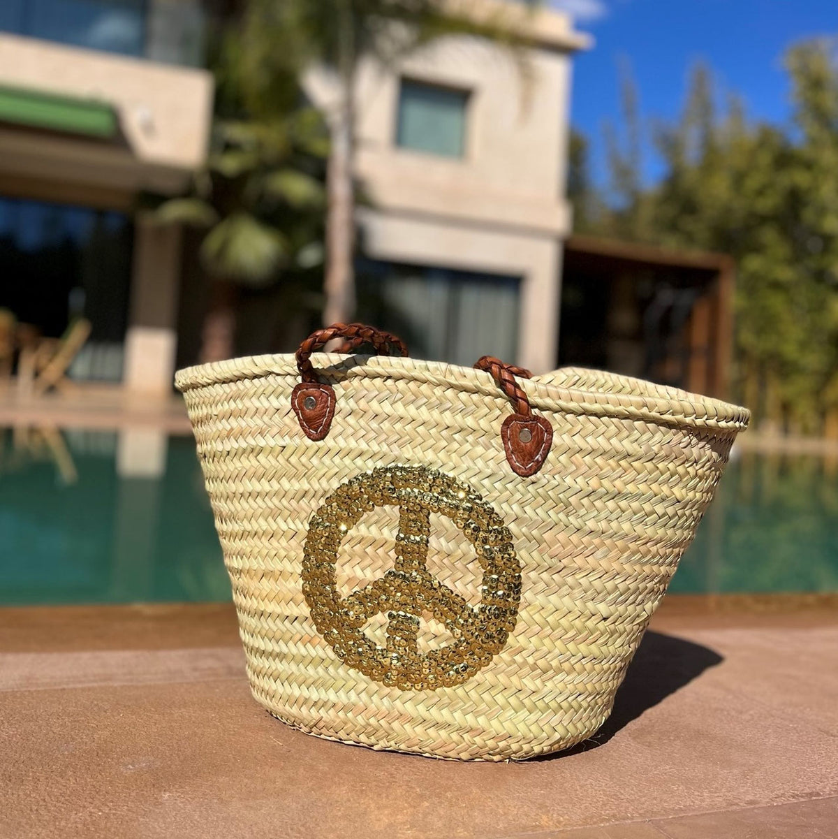 Rieten strandtas met pailletten Peace goud, bij het zwembad