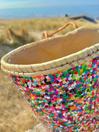 Straw beach bag with sequins pink, purple and green, close up of the sequins