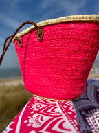 Rieten strandtas met pailletten roze, op een strandlaken
