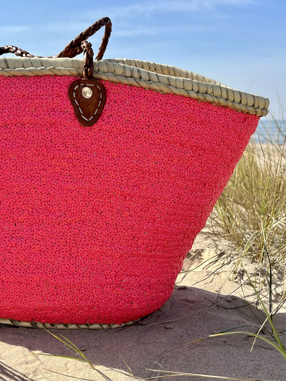 Rieten strandtas met pailletten roze, vooraanzicht in de duinen