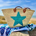 Straw beach bag with sequins Star turquoise, on a beach blanket