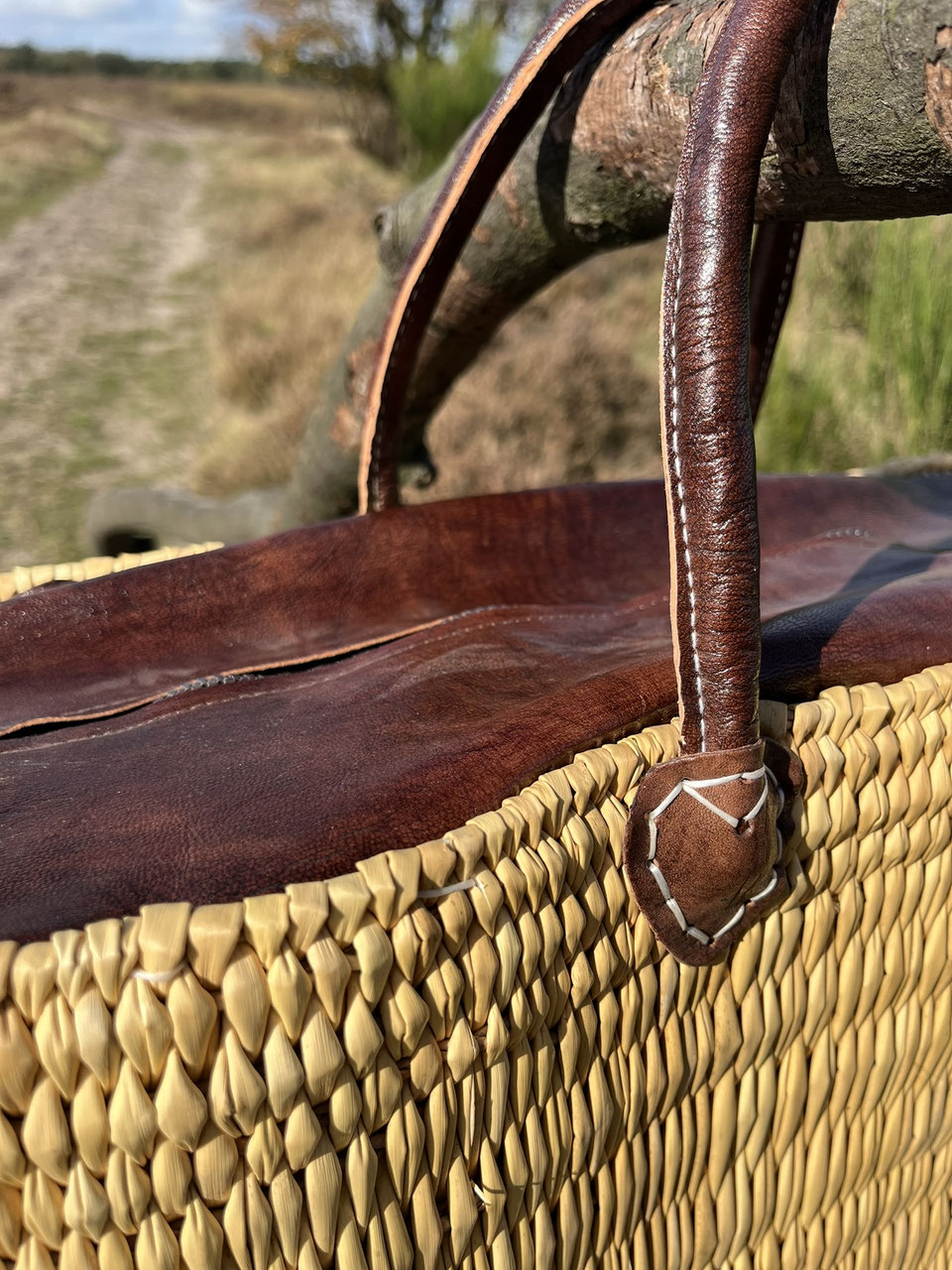 Rieten tas Faria met leren sluiting, close-up van het vlechtwerk en de leren rand