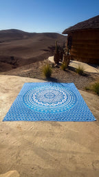 XXL strandlaken Blue Ombre 235x220 cm, uitgespreid op zandsteen onder een blauwe lucht