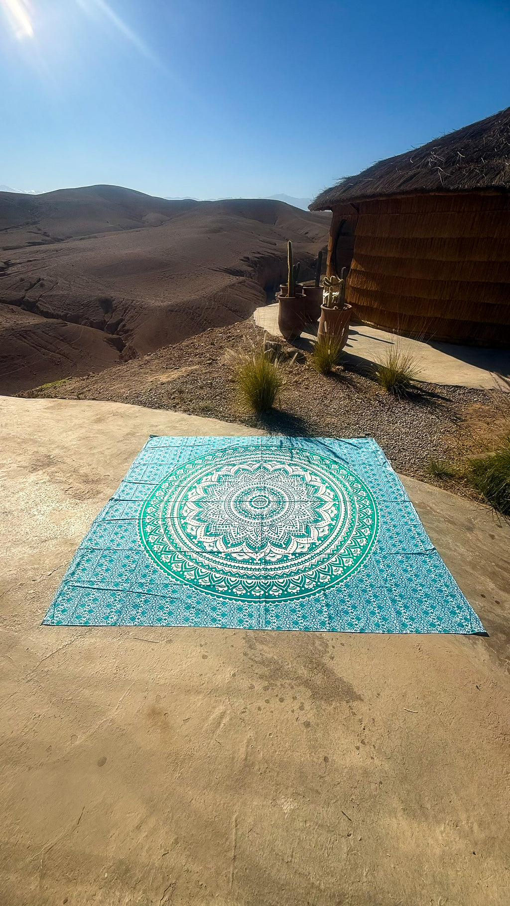 XXL strandlaken Green Ombre 235x220 cm, uitgespreid op zandsteen onder een blauwe lucht