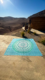 XXL strandlaken Green Ombre 235x220 cm, uitgespreid op zandsteen onder een blauwe lucht